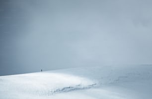 a person standing on top of a snow covered slope