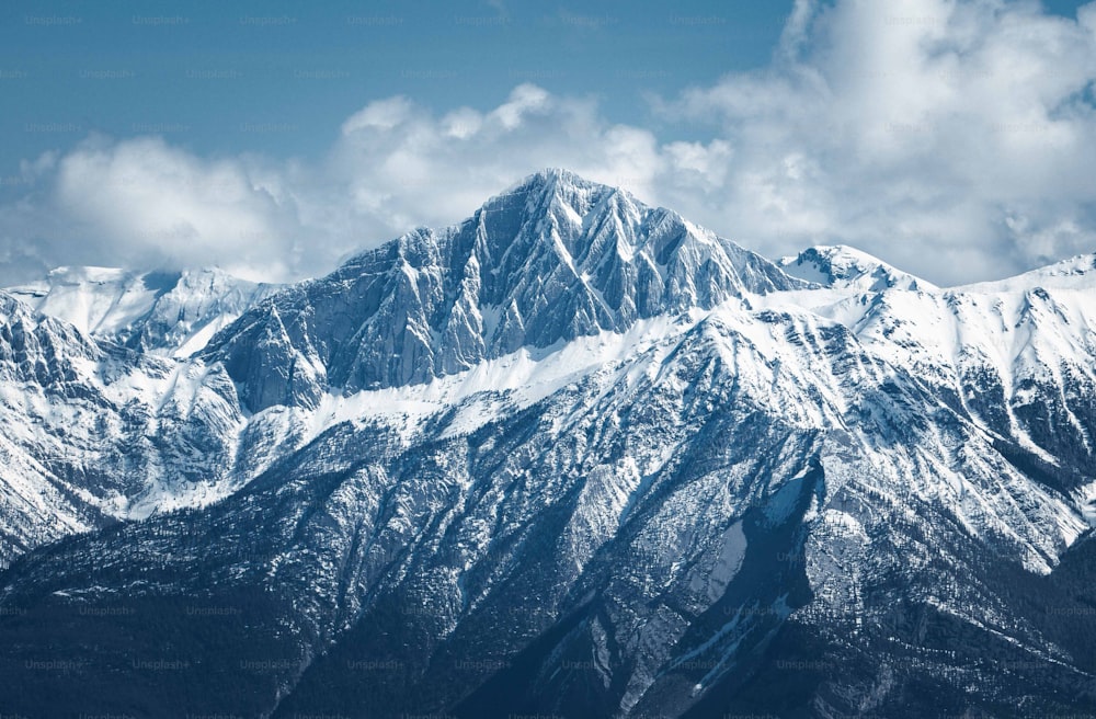 a mountain range covered in snow under a blue sky