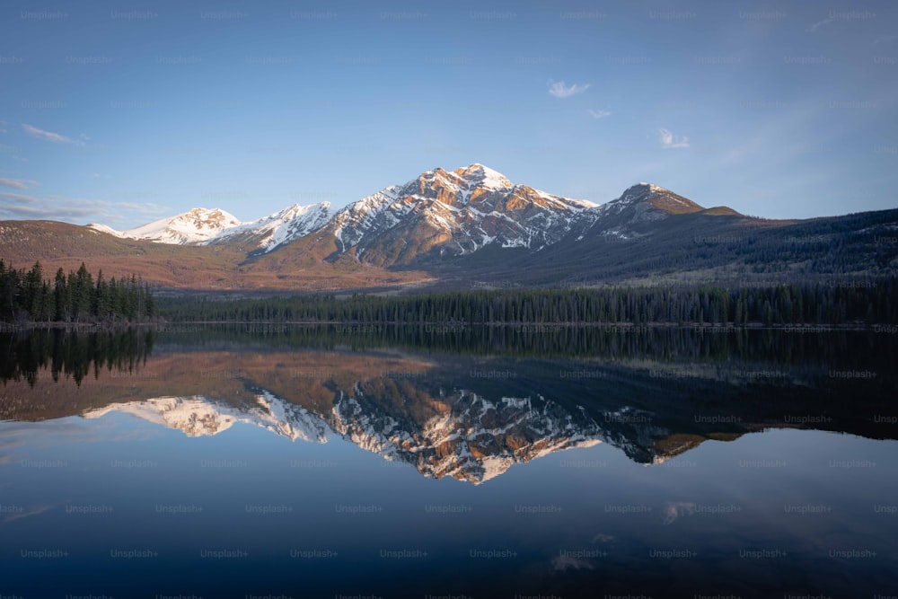 Una montaña se refleja en el agua quieta de un lago