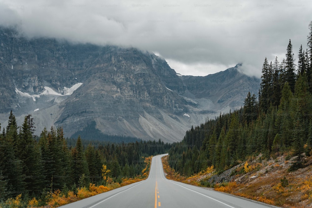 uma longa estrada com uma montanha ao fundo