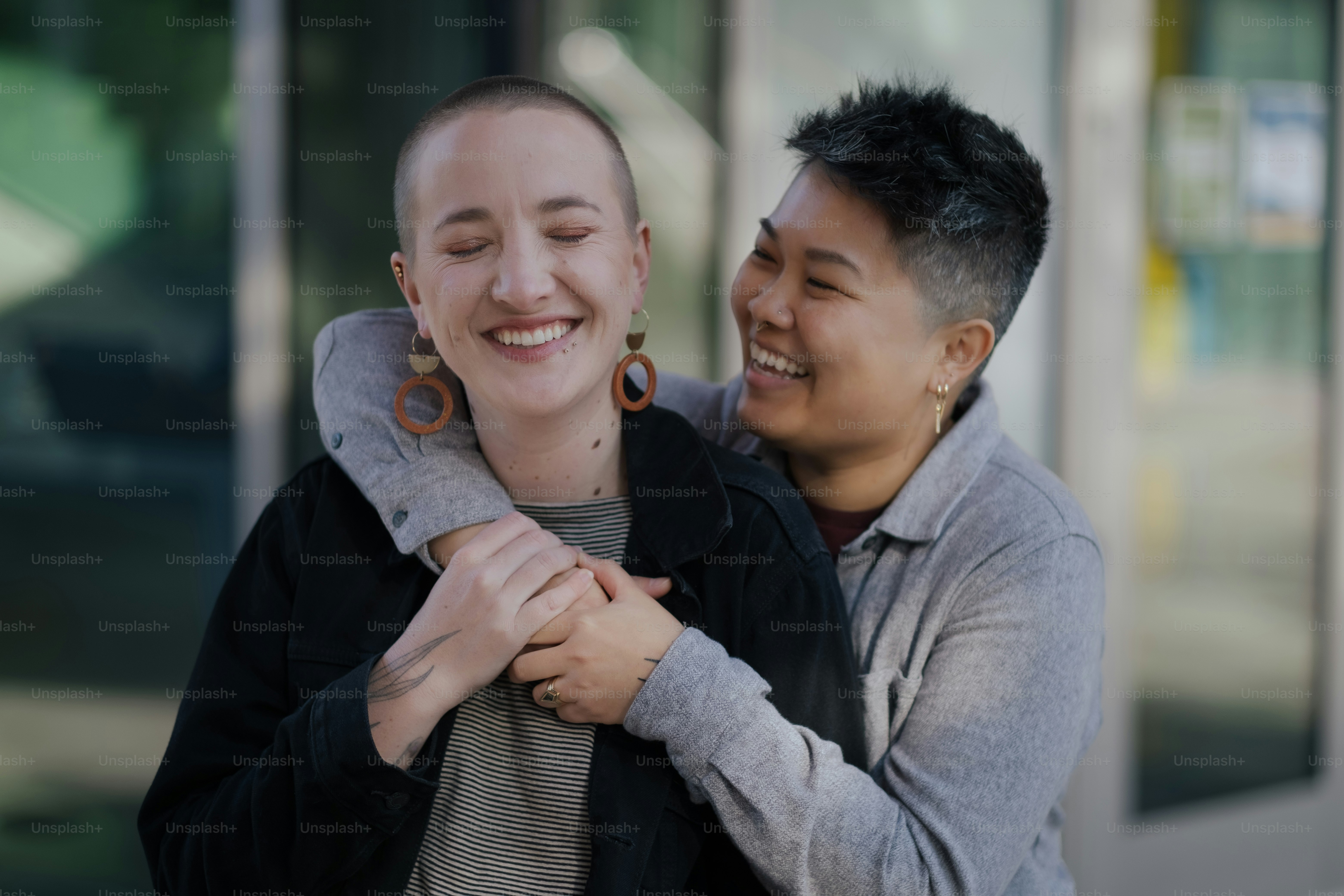 a woman holding a man's neck in front of a building