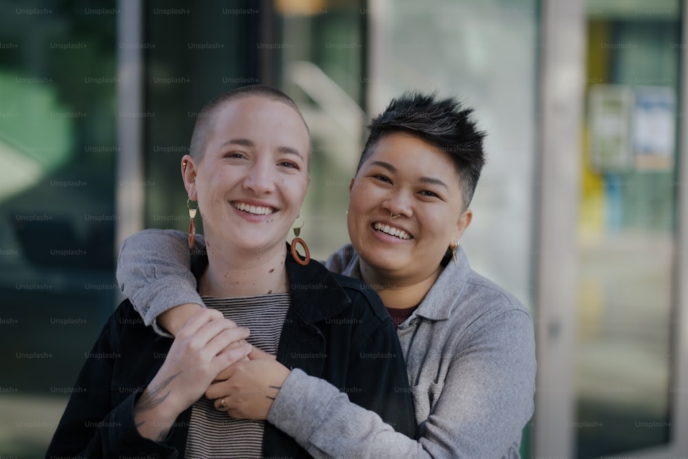 two people standing next to each other in front of a building