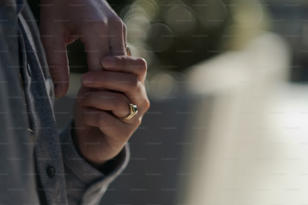 um close up de uma pessoa segurando um anel