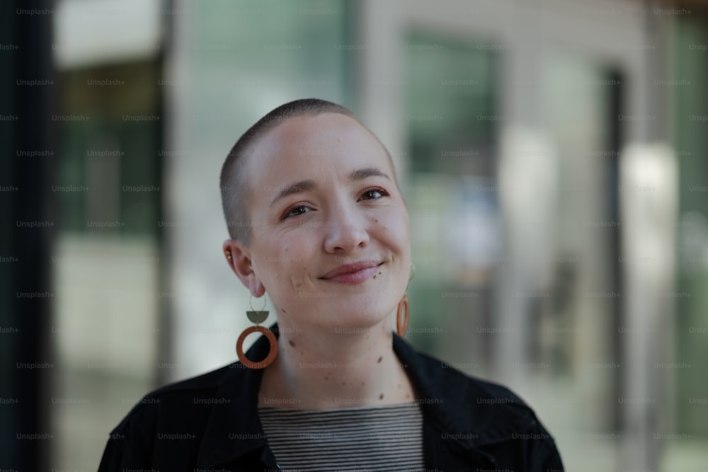 a woman with a shaved head and earrings