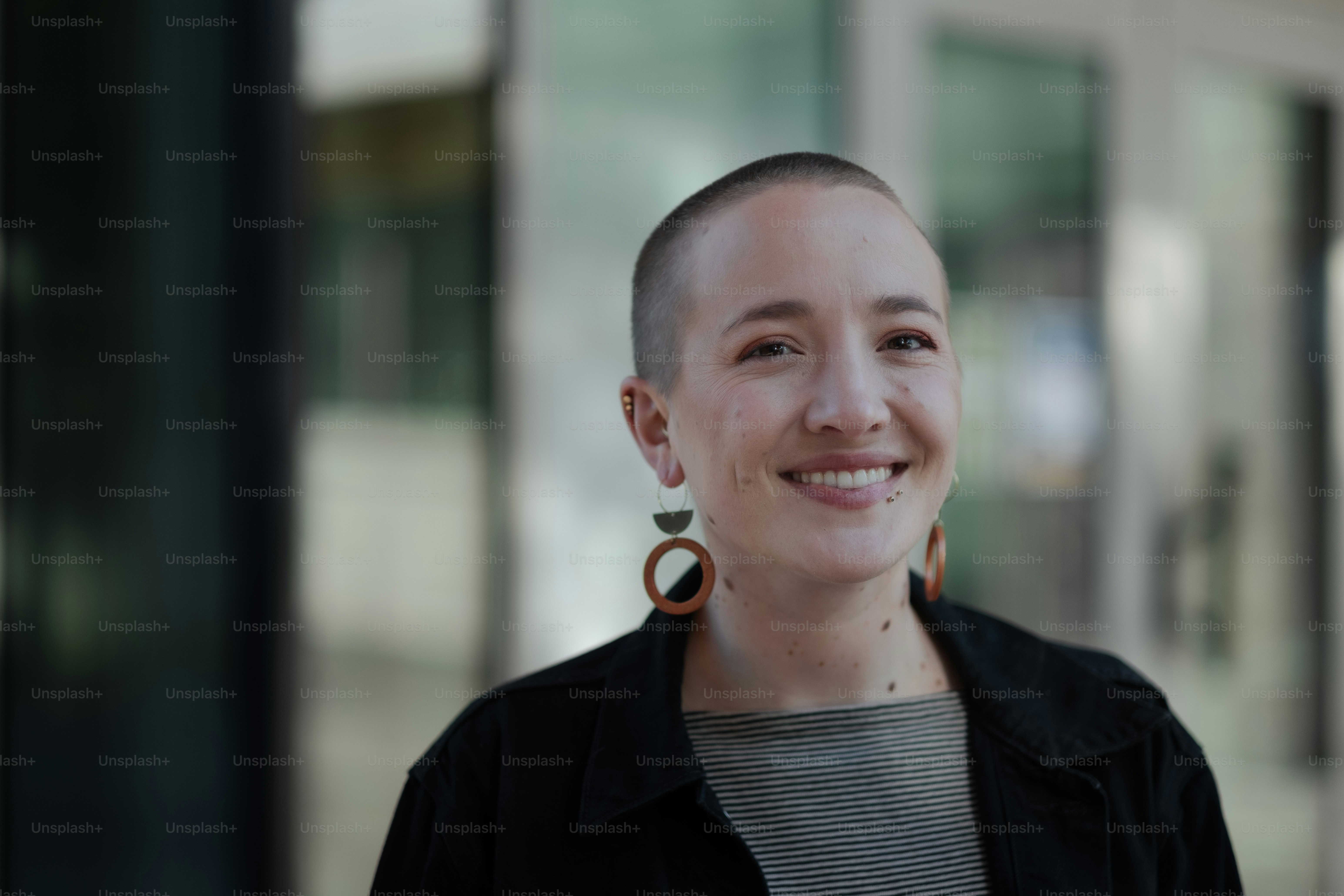 a woman with a shaved head and large earrings