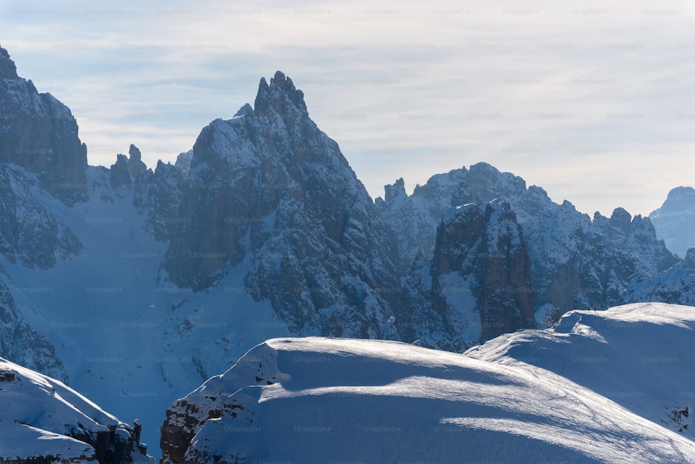 a group of mountains covered in snow under a blue sky