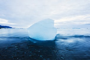 a large iceberg floating on top of a body of water