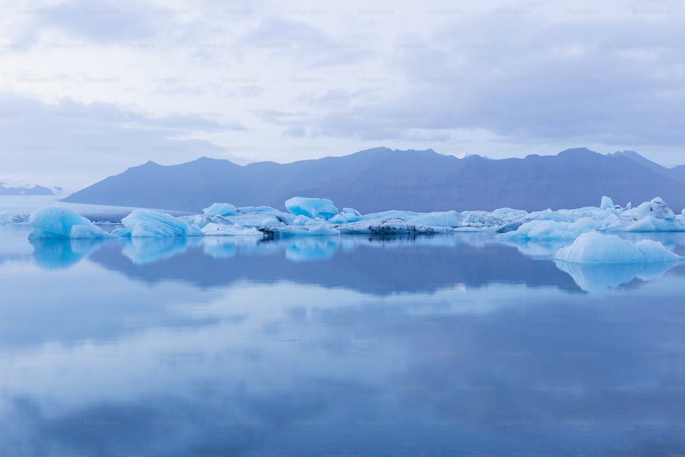 a group of icebergs floating on top of a lake