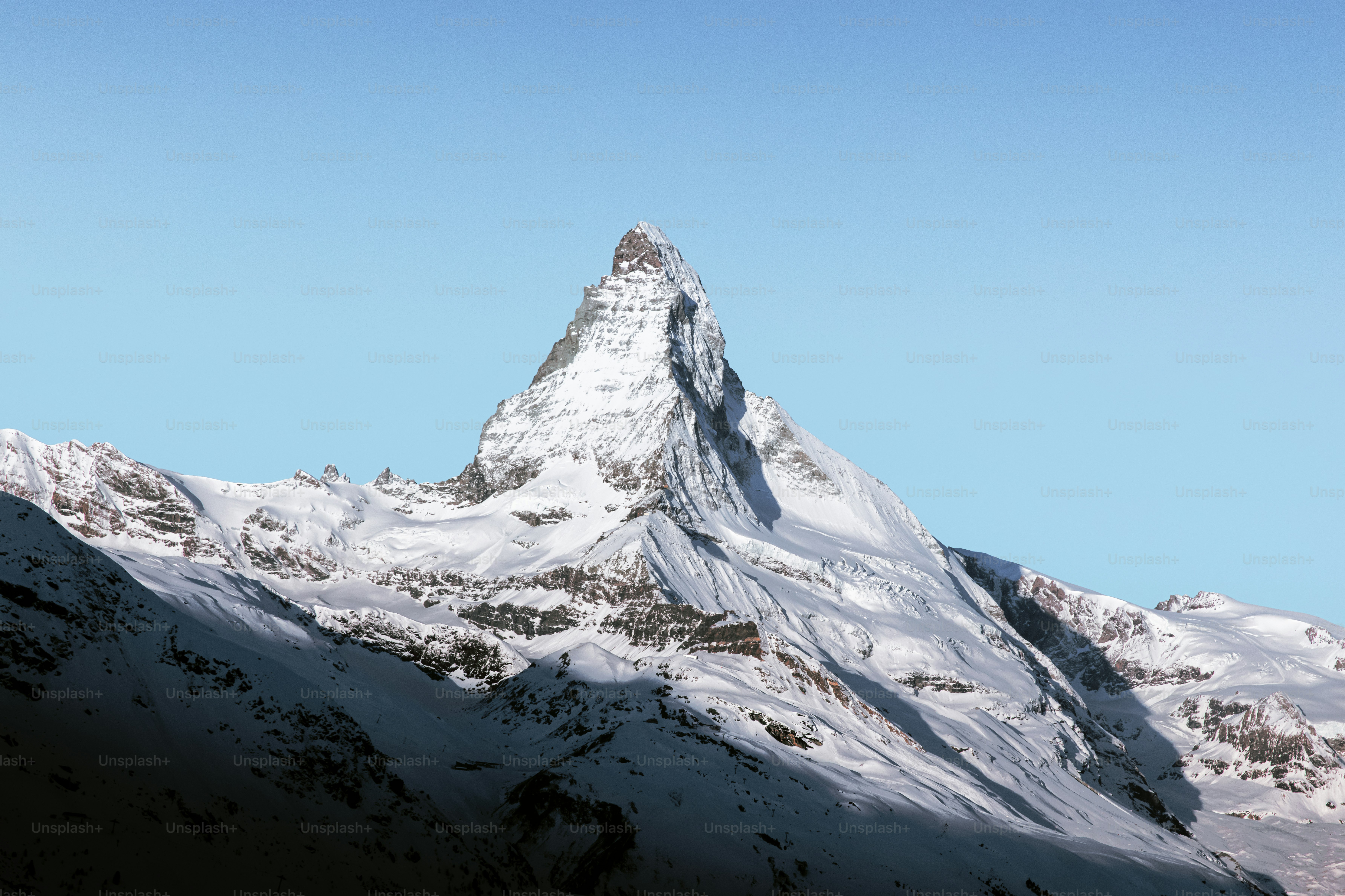 Una montaña cubierta de nieve con un cielo azul en el fondo