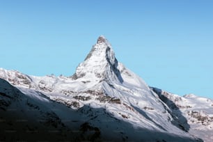 Une montagne enneigée avec un ciel bleu en arrière-plan