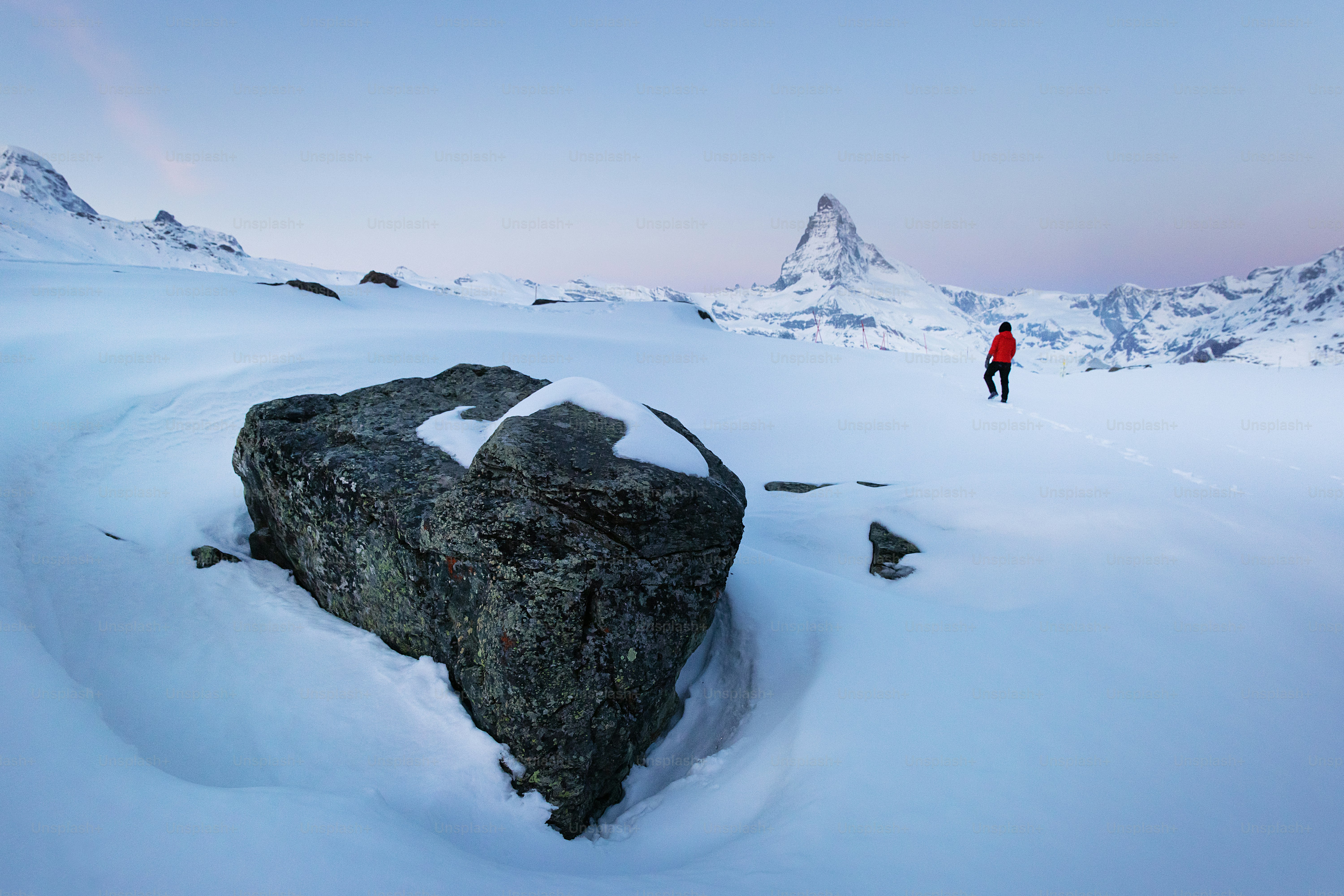 Un hombre parado en la cima de una montaña cubierta de nieve