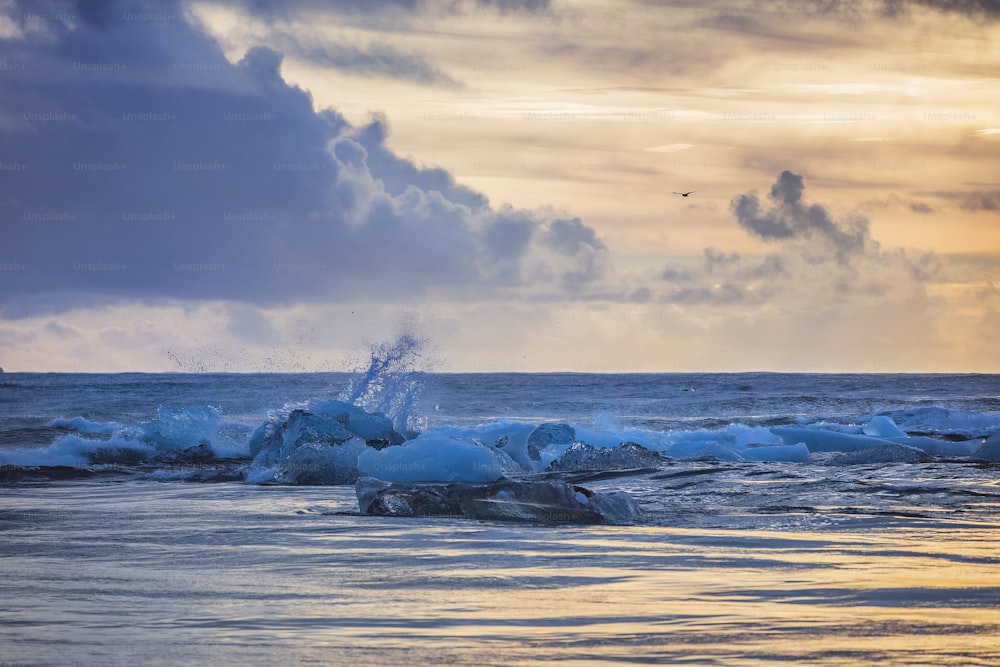 un plan d’eau avec des vagues qui s’écrasent contre les rochers