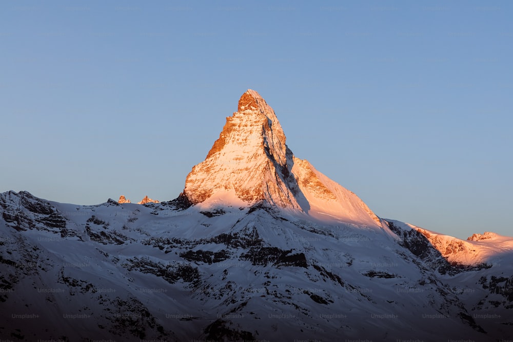 a snow covered mountain with a blue sky in the background