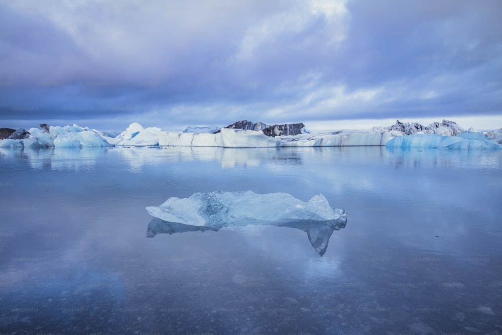 um grande iceberg flutuando em cima de um corpo de água