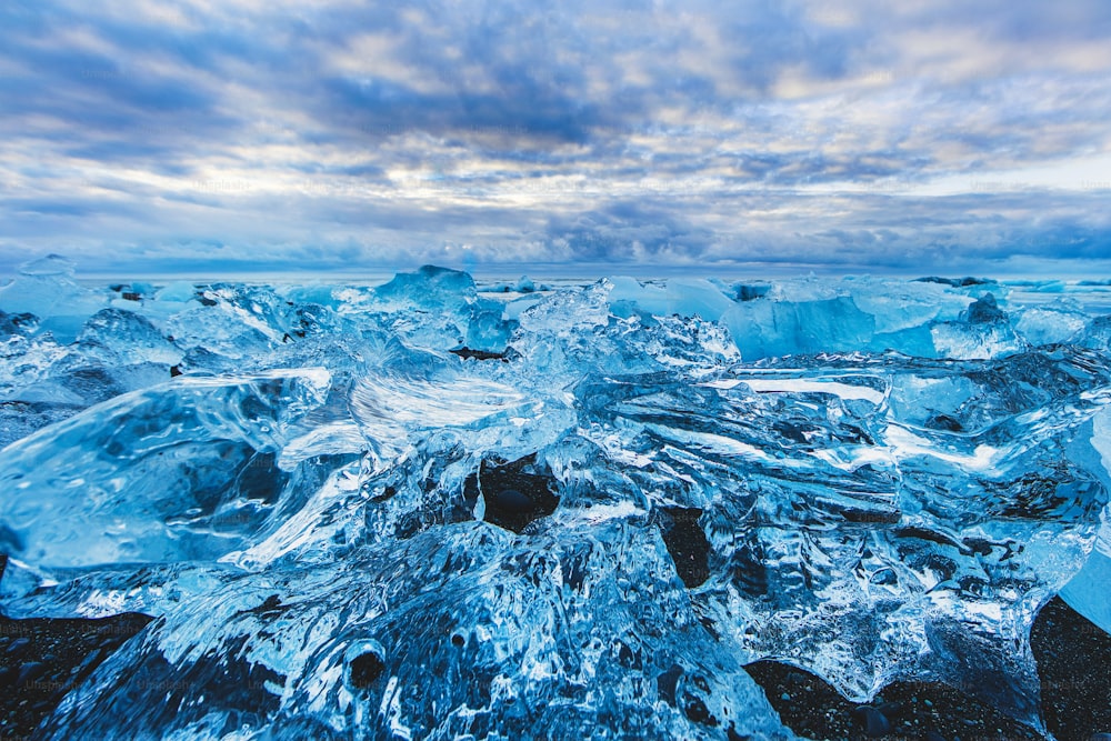 um grande grupo de icebergs flutuando em cima de um corpo de água