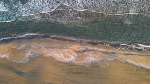 an aerial view of a beach with waves and sand