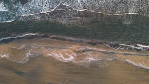 an aerial view of a beach with waves and sand