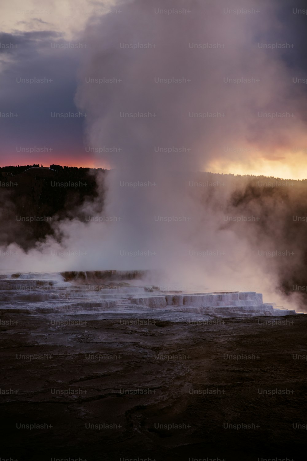 Un geyser che sputa acqua nell'aria al tramonto