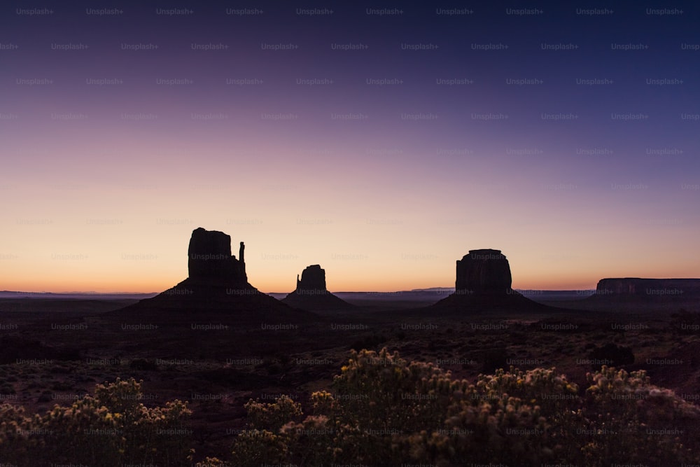 Il sole sta tramontando sul deserto con le montagne sullo sfondo