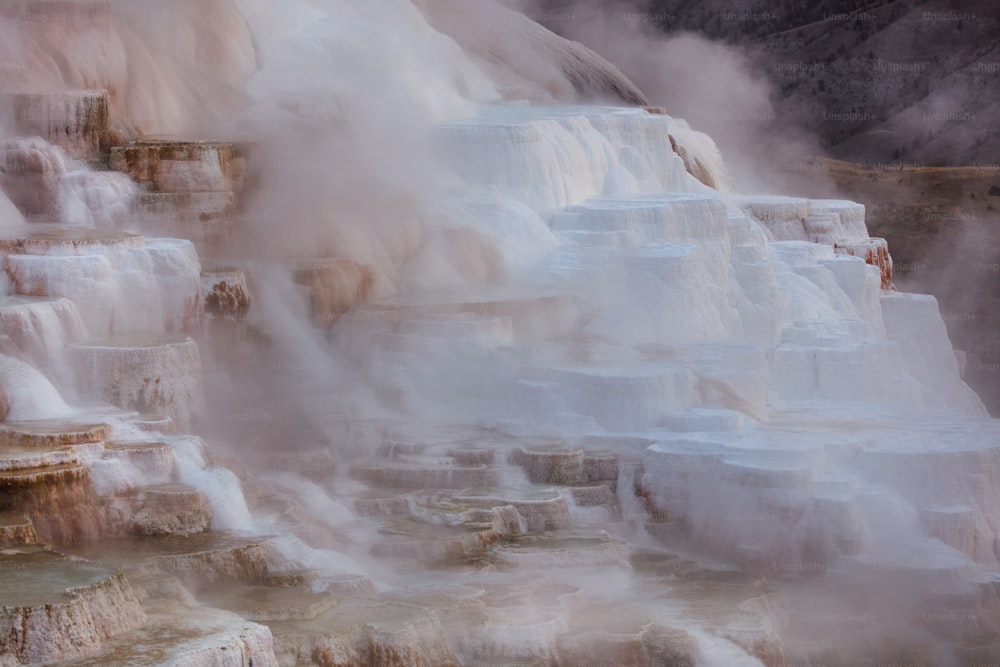 a geyser spewing water into the air with steam coming out of