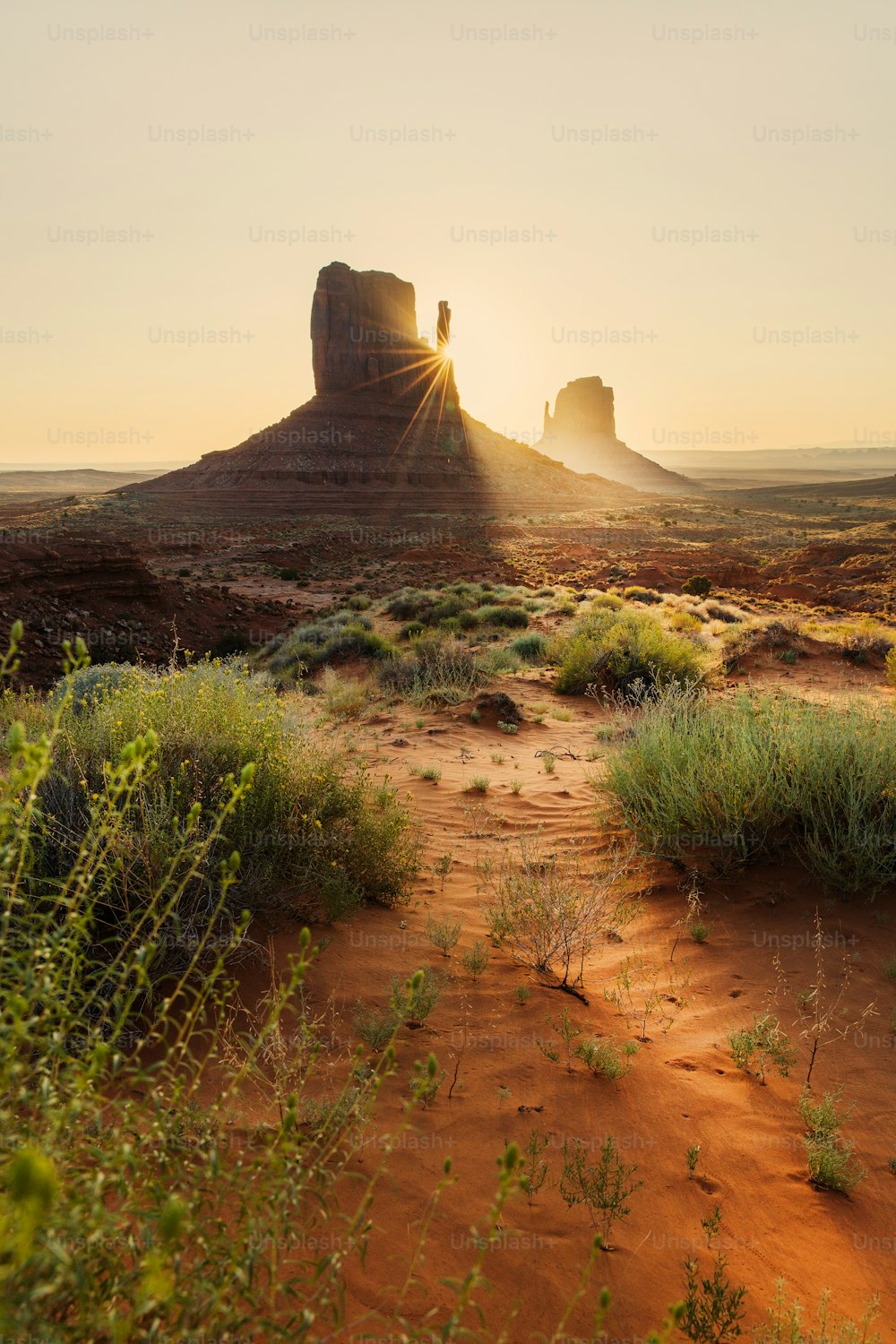 the sun is setting over a desert landscape