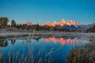 a beautiful view of a mountain range with a lake in the foreground