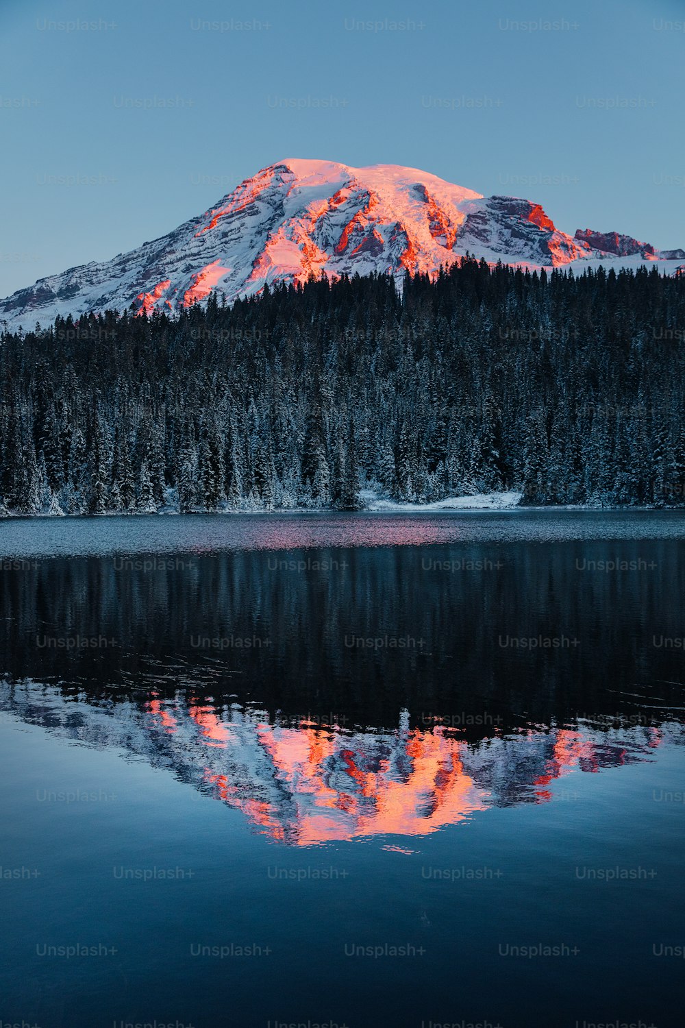 Una montagna è mostrata con un lago di fronte ad essa