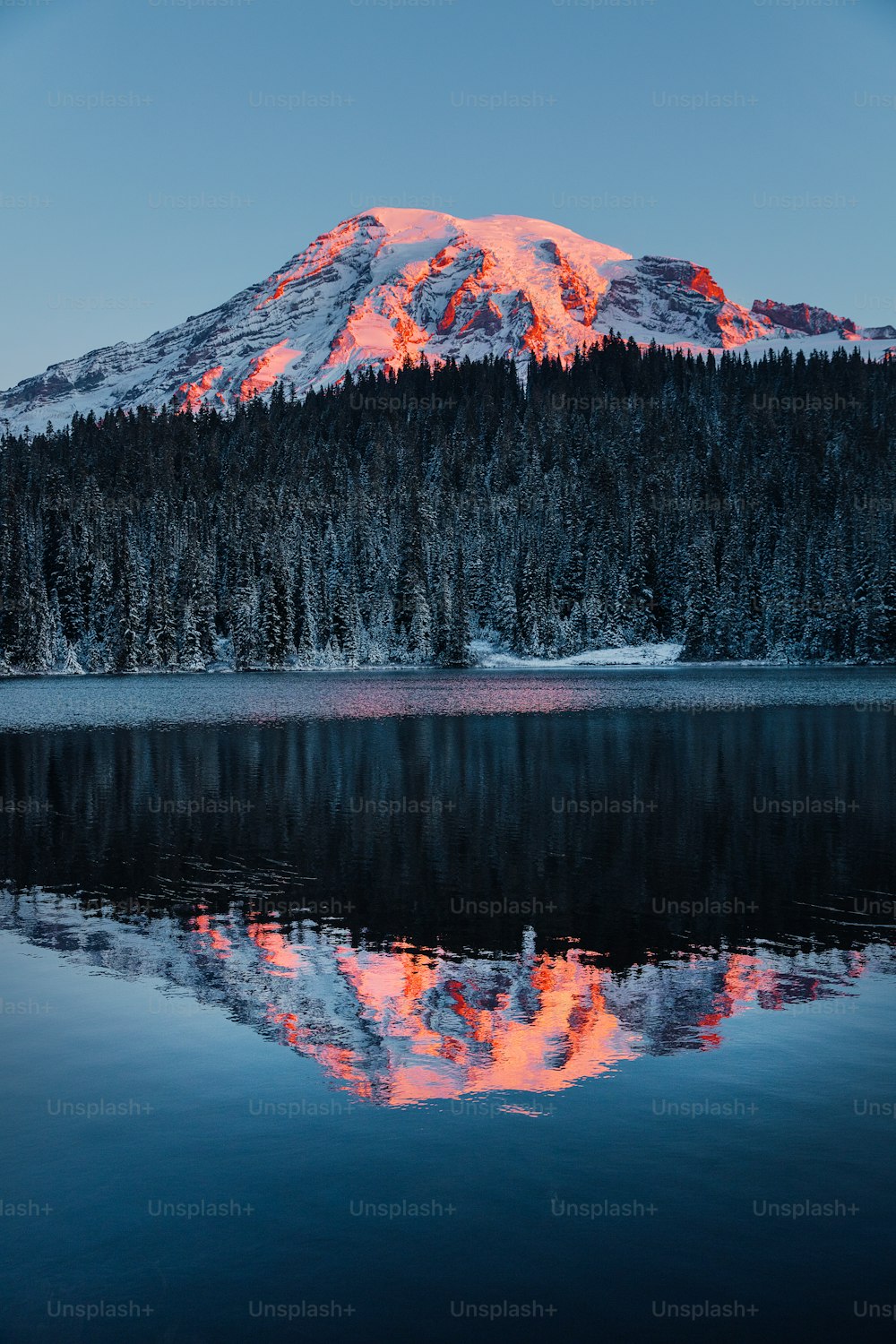 Une montagne est représentée avec un lac devant elle