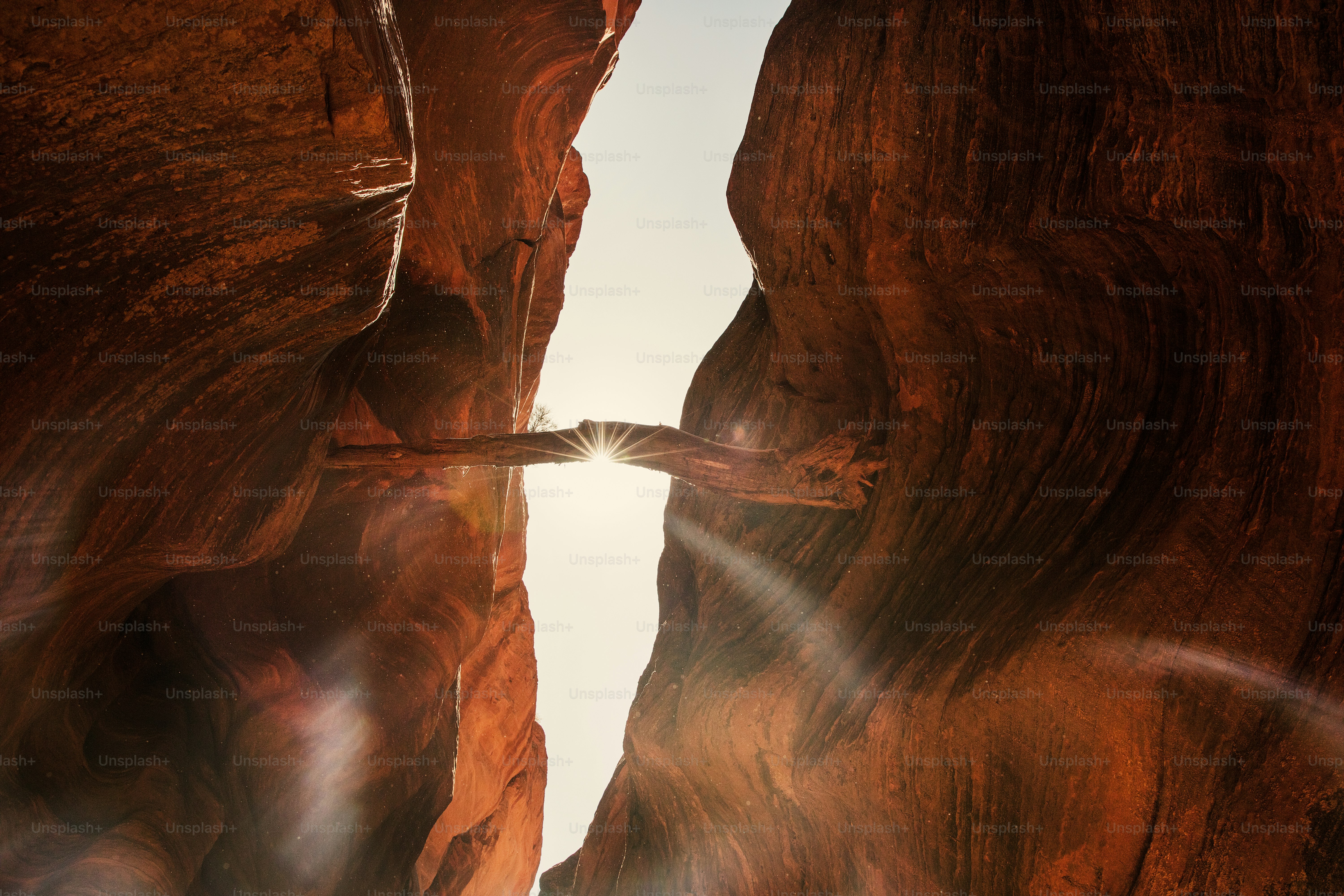 the sun shines through a narrow slot in a canyon