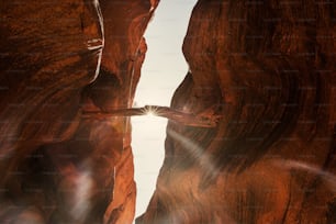 the sun shines through a narrow slot in a canyon