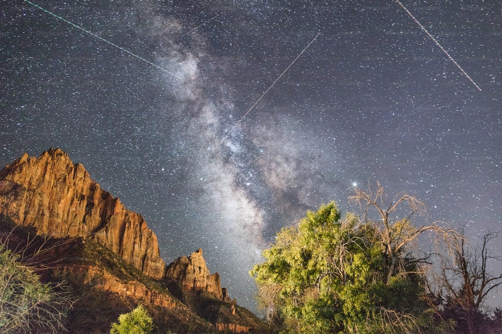 a view of the night sky with a star trail in the background