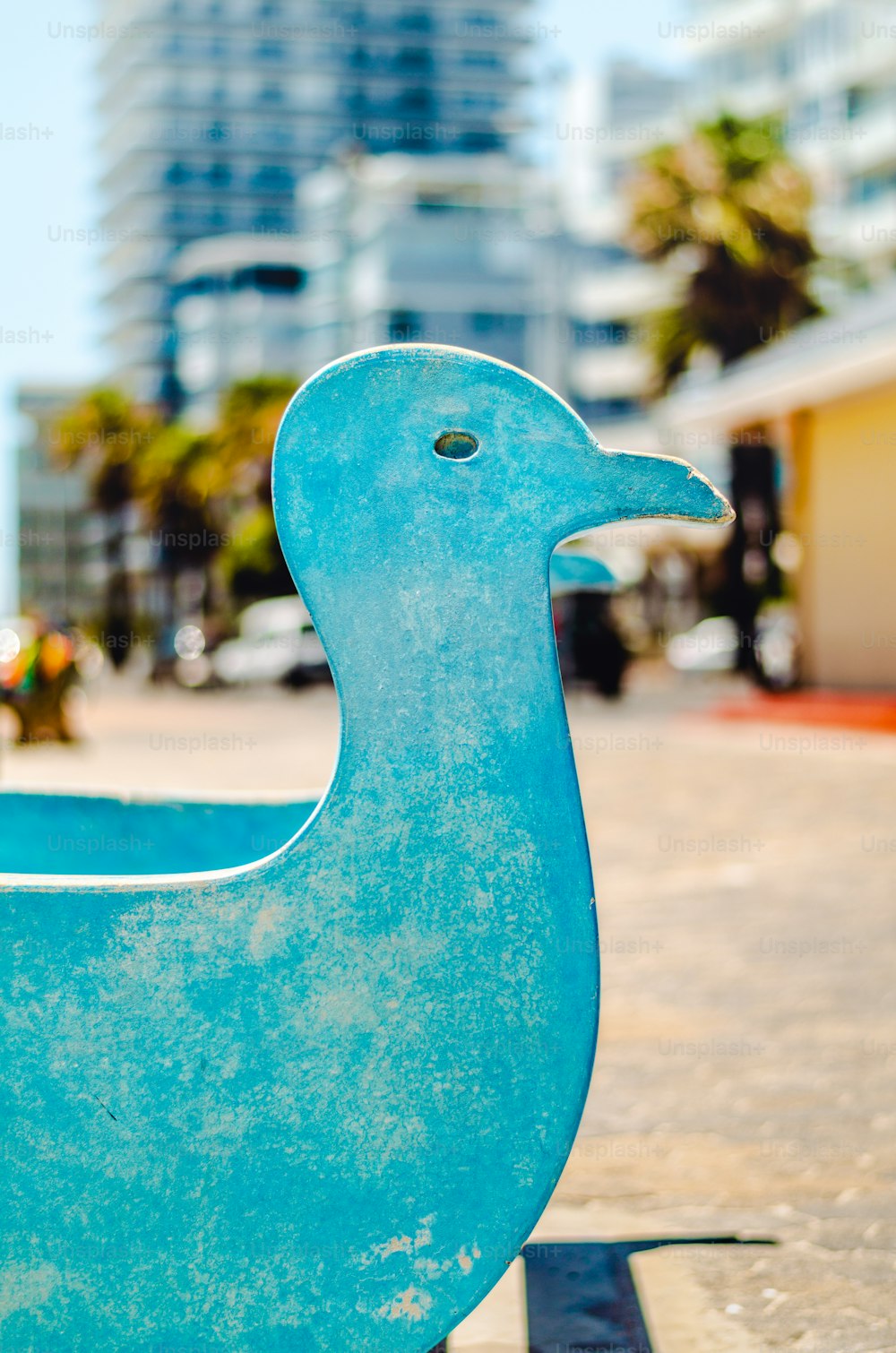 a statue of a blue duck on a sidewalk