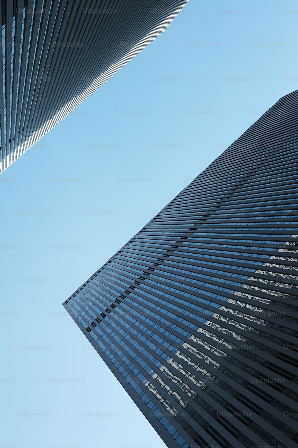 two tall buildings with a blue sky in the background