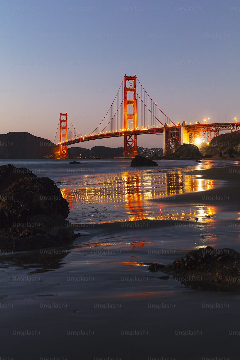 the golden gate bridge is lit up at night