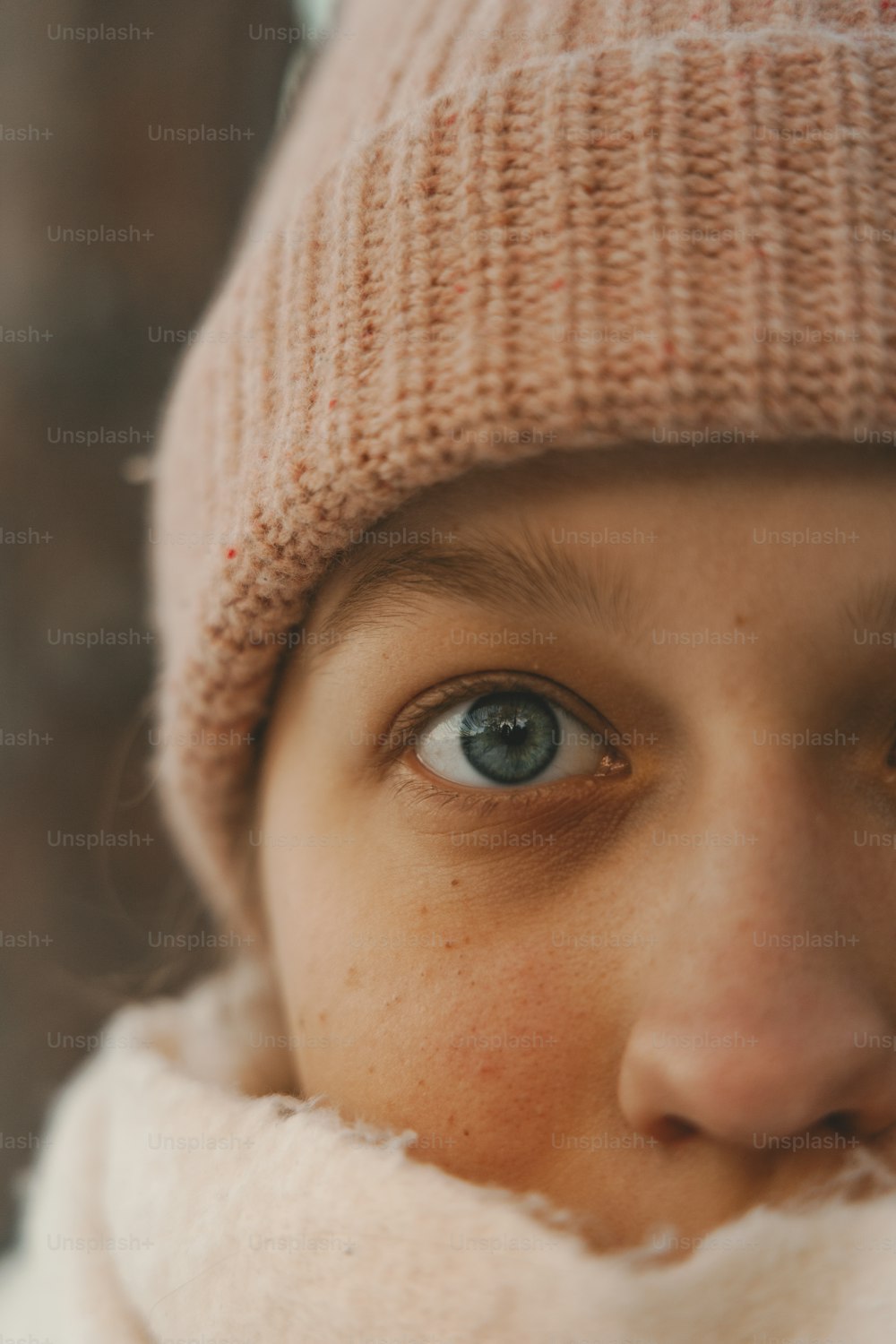 a close up of a person wearing a hat and scarf
