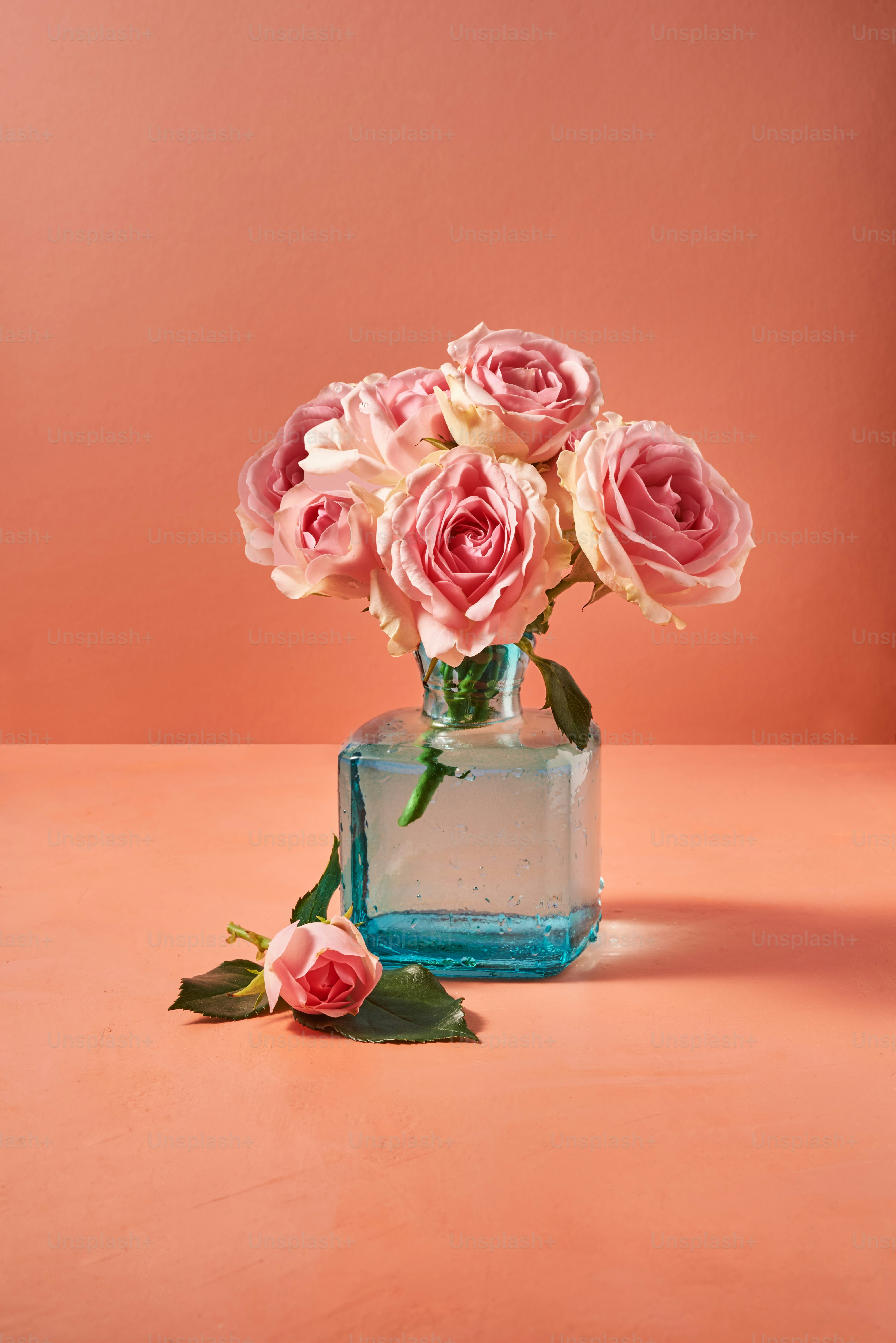 a vase filled with pink roses on top of a table