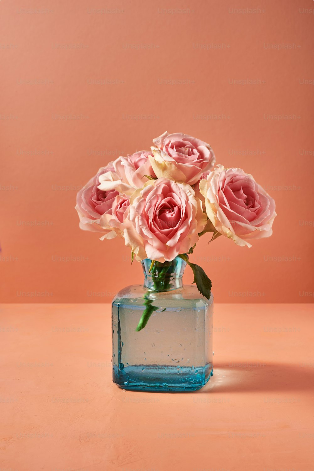 a vase filled with pink roses on top of a table