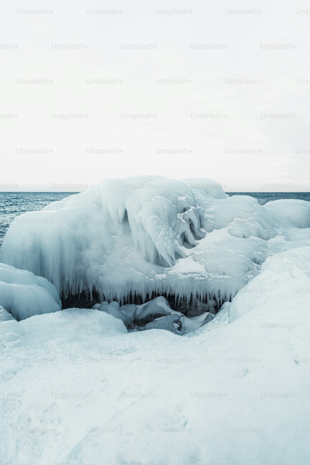 a large chunk of ice on the shore of a body of water