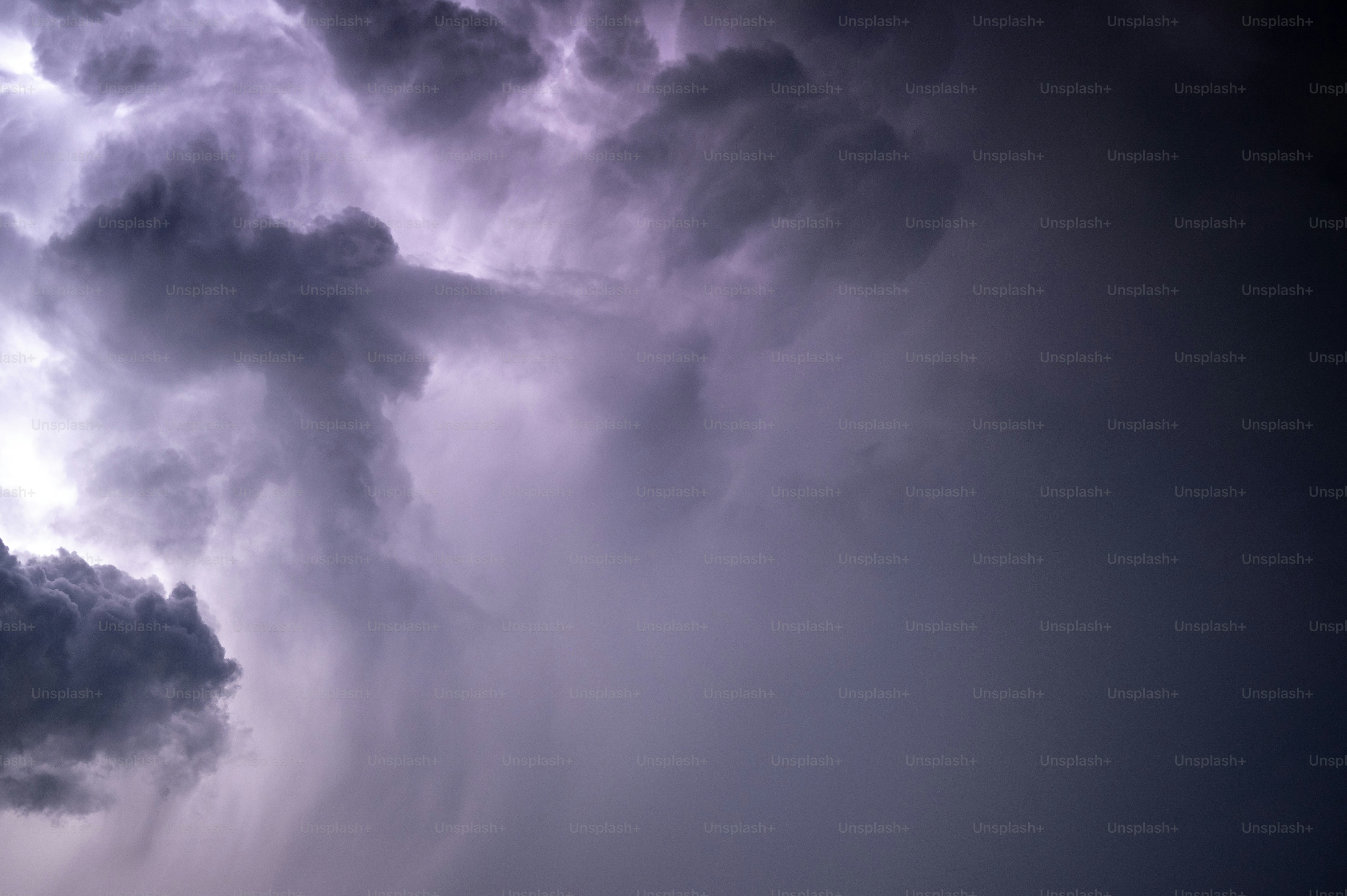 a very dark and cloudy sky with a plane in the foreground