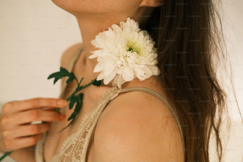 Una mujer sosteniendo una flor en la mano