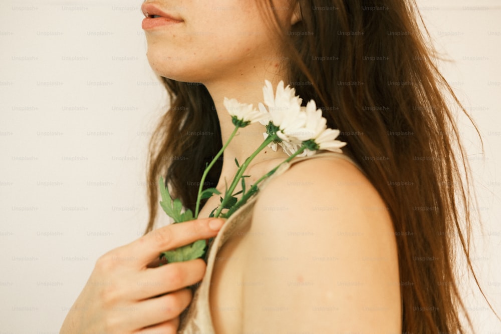 a woman holding a flower in her right hand