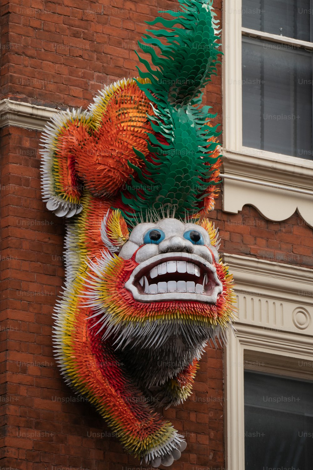 Une tête de dragon suspendue sur le côté d’un bâtiment