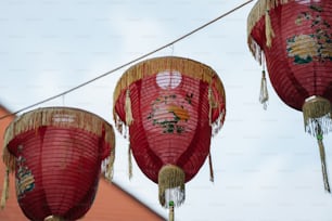 three red paper lanterns hanging from a string