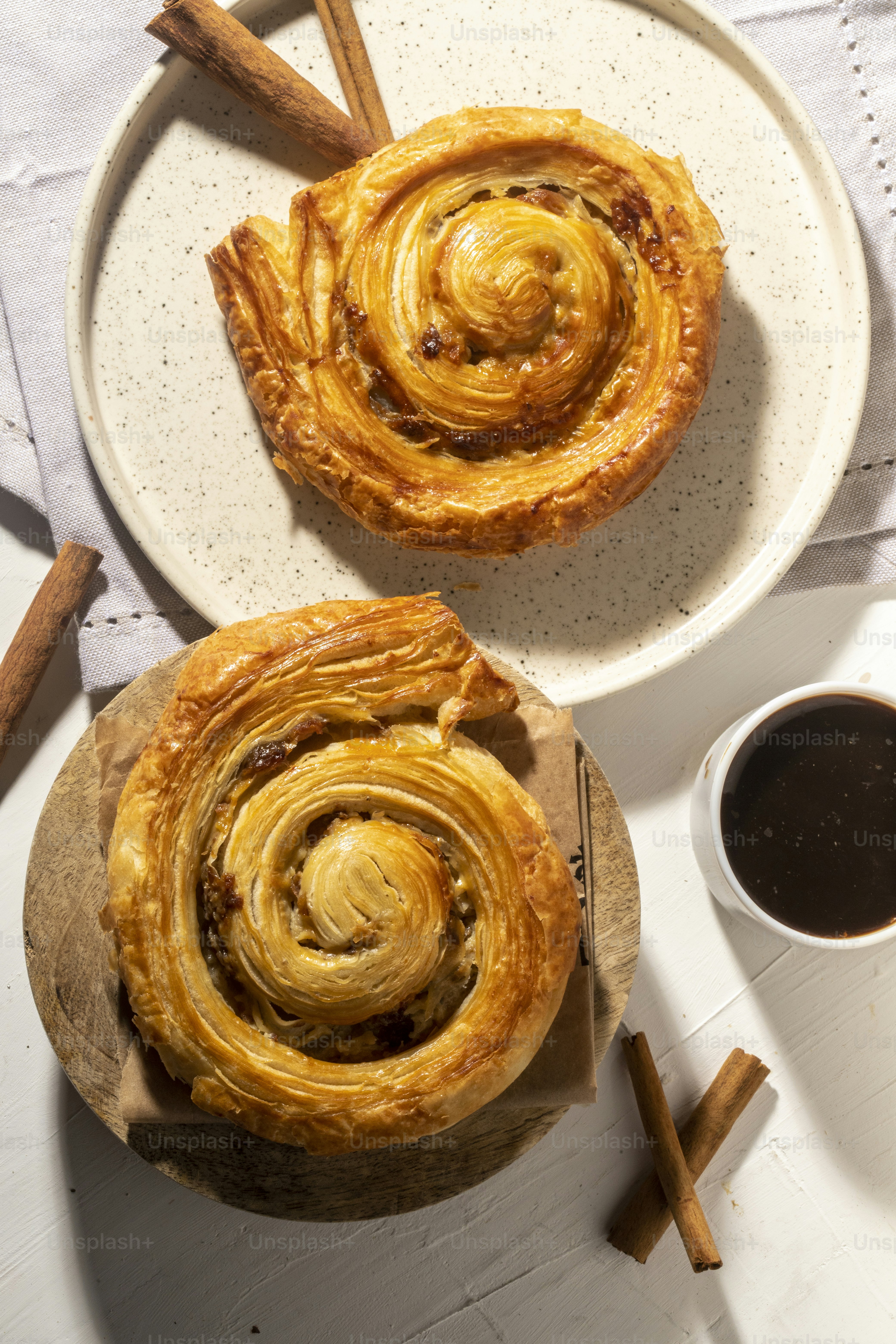 Dos pasteles sentados en un plato junto a una taza de café