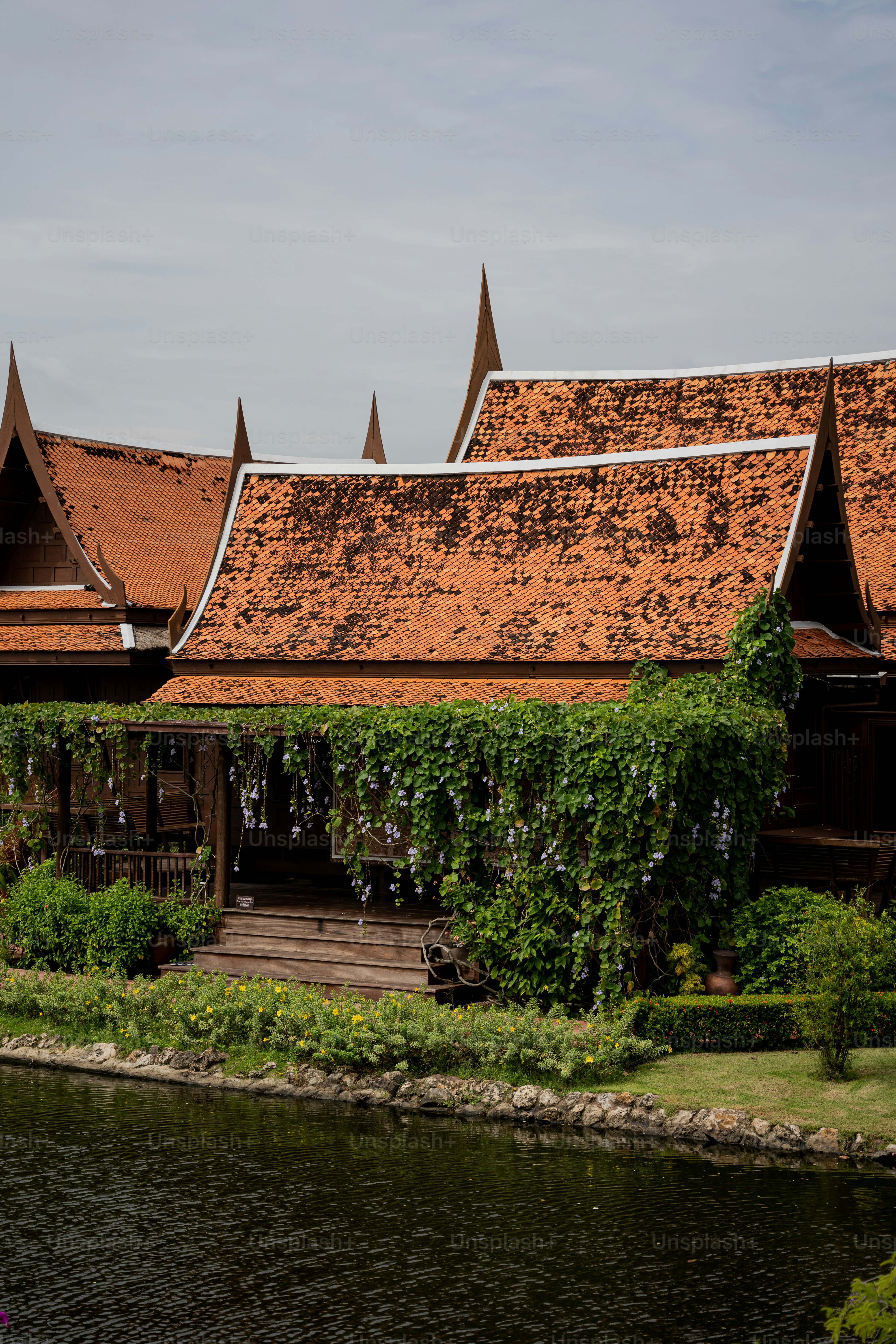 a building with a brown roof next to a body of water