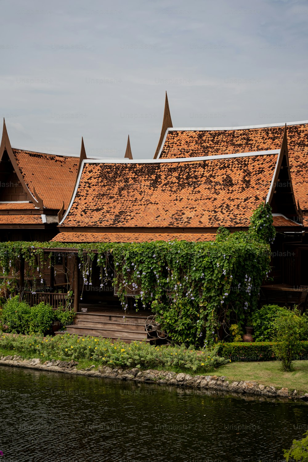 a building with a brown roof next to a body of water
