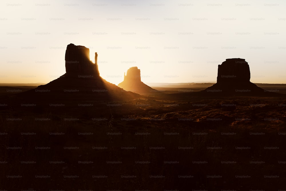 the sun is setting over a desert landscape