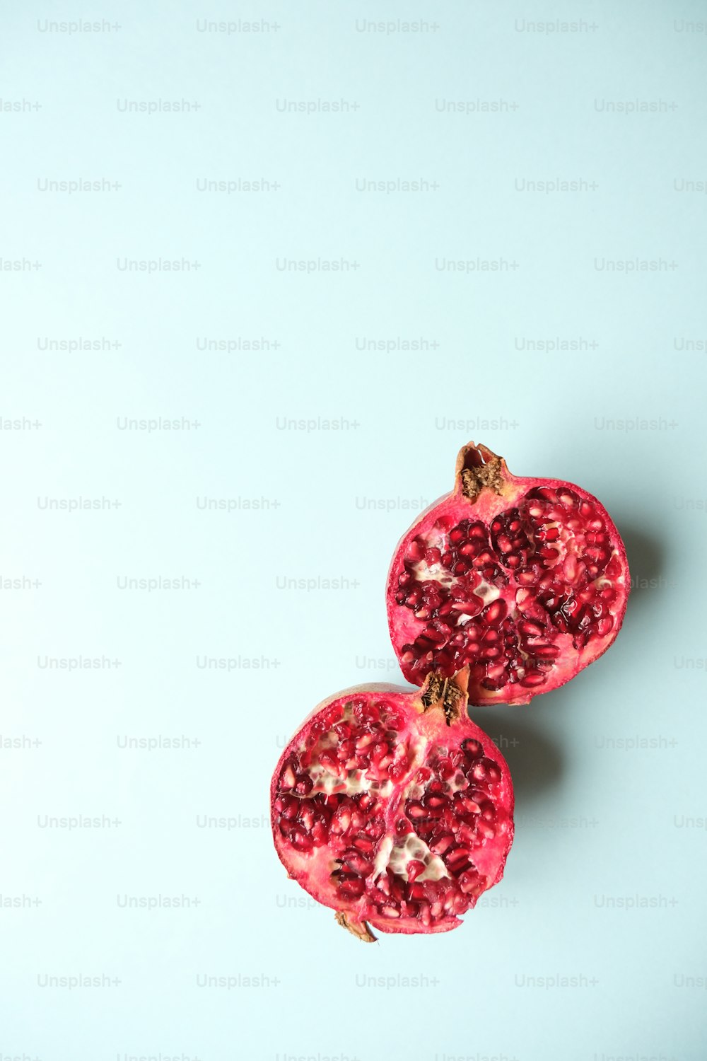 two halves of a pomegranate on a blue background