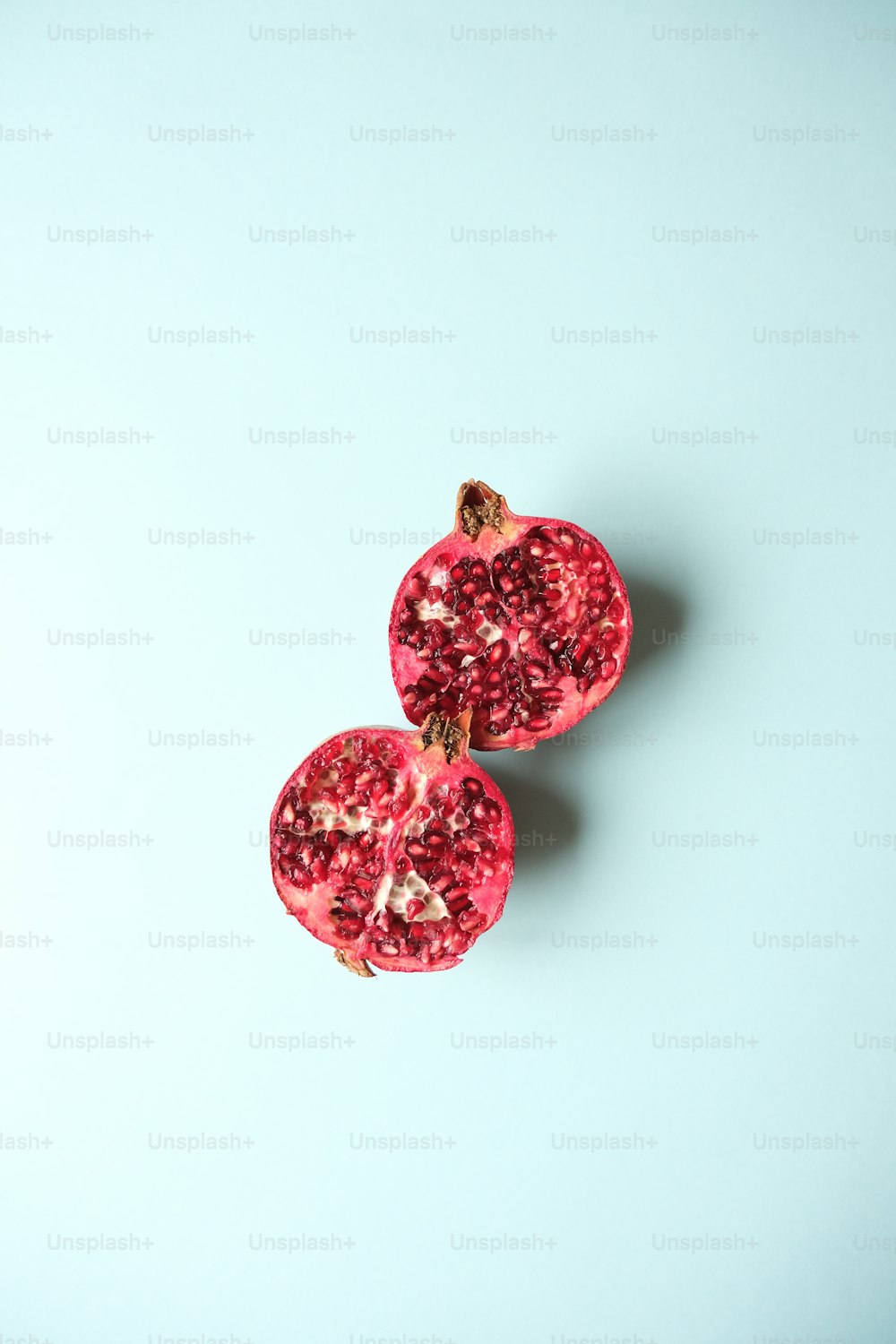 two halves of a pomegranate on a blue background