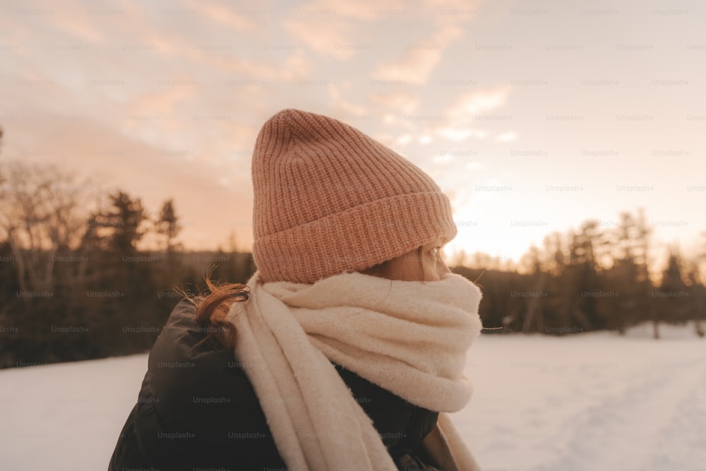 a woman wearing a pink hat and scarf in the snow